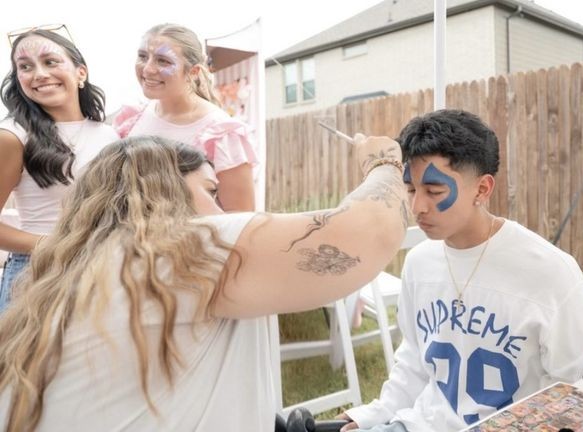 Face painting artist working at an outdoor teen party in Texas