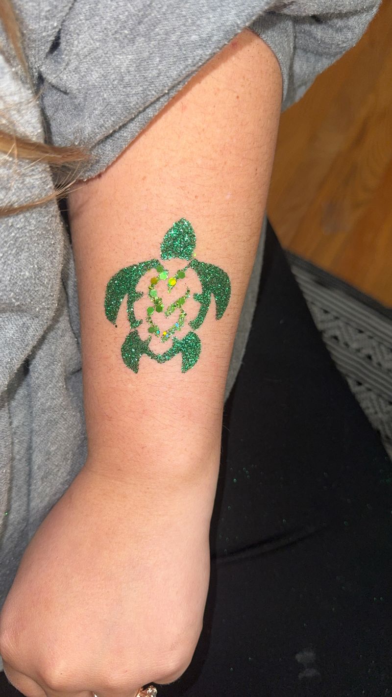 Green sea turtle glitter tattoo design on an arm in Texas